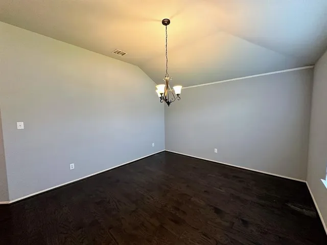 a view of a room with wooden floor and ceiling fan