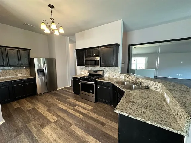 a kitchen with granite countertop stainless steel appliances and a counter space