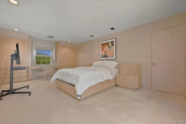 a spacious bedroom with a bed and a painting on the wall