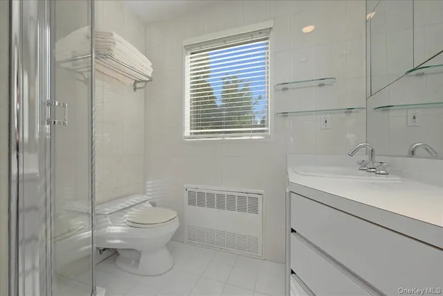 a bathroom with a toilet sink vanity and windows