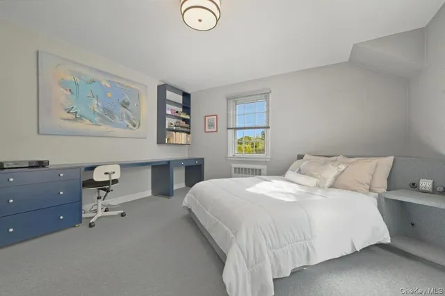 a bedroom with a bed and painting on the wall