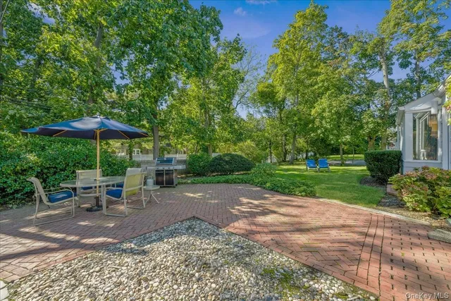 a view of a backyard with chairs under an umbrella