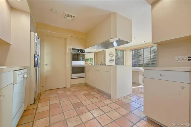 a view of a kitchen with white cabinets and refrigerator