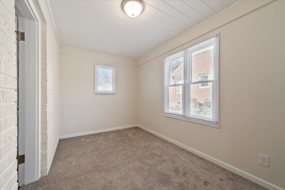 753 Ivy Road Memphis, TN 38117 - Photo 3 of 25 Spare room featuring brick wall, ornamental molding, and carpet floors