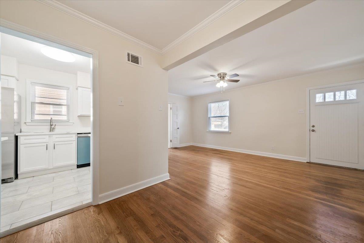 753 Ivy Road Memphis, TN 38117 - Photo 5 of 25 Unfurnished living room with ornamental molding, light wood-style floors, and a ceiling fan