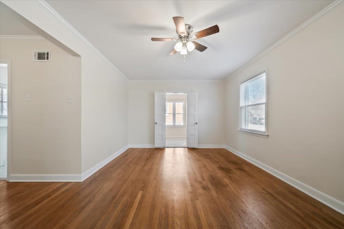 753 Ivy Road Memphis, TN 38117 - Photo 7 of 25 a view of an empty room with wooden floor and a window