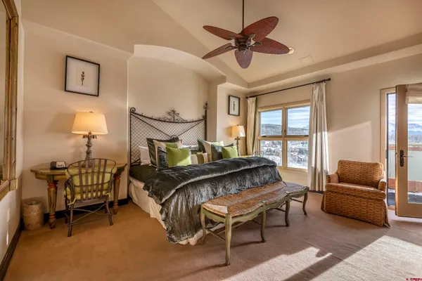 a bedroom with a bed a chandelier and a window