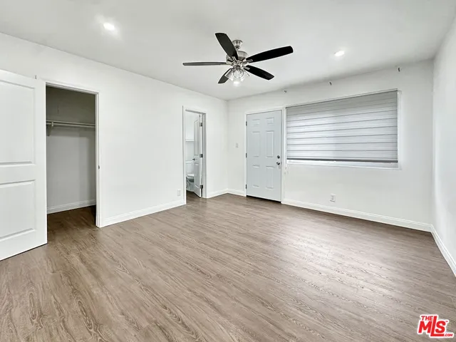 a view of a livingroom with wooden floor and a ceiling fan