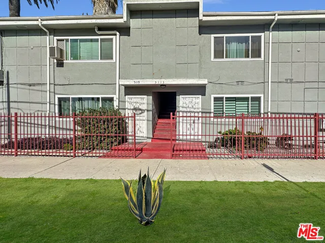 a view of a house with a small yard and wooden fence
