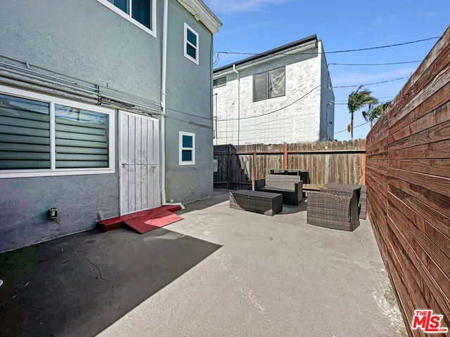 a balcony with couch and wooden fence