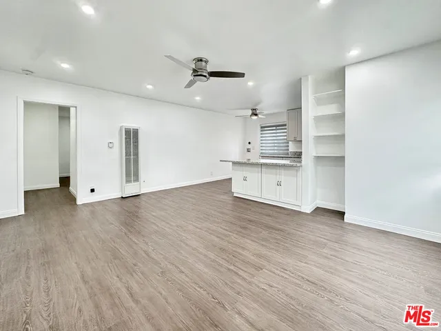 wooden floor in an empty room with a kitchen