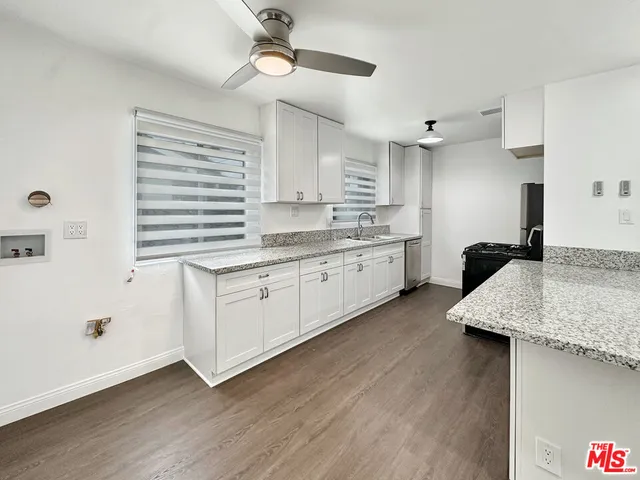 a kitchen with a sink cabinets stainless steel appliances and a window