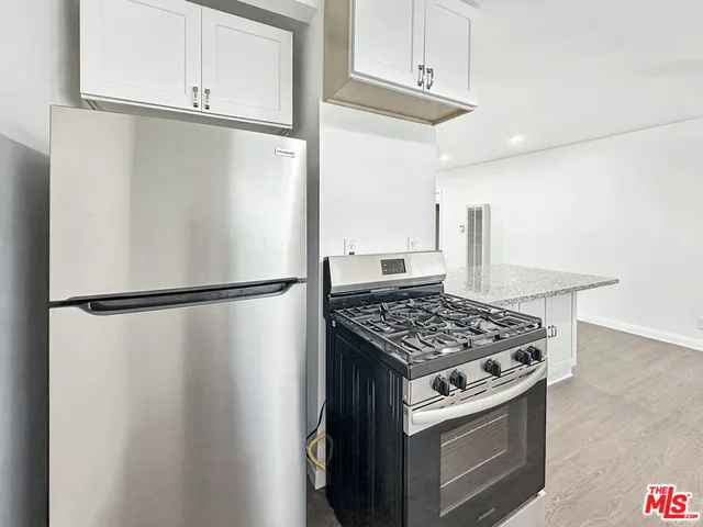 a kitchen with stainless steel appliances granite countertop a refrigerator and a stove