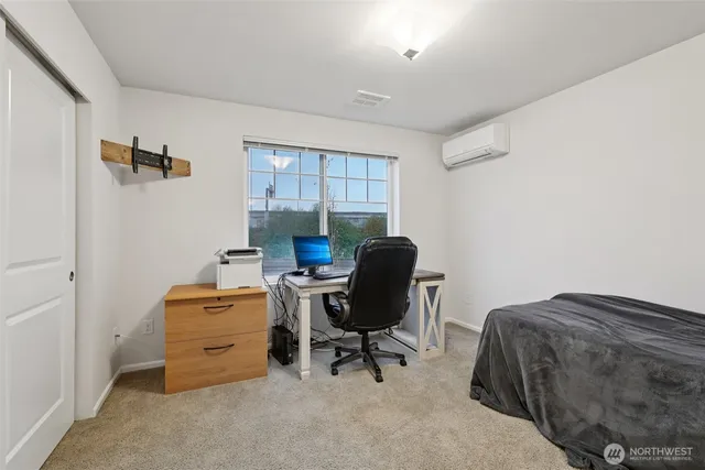 a view of a workspace with furniture and a window