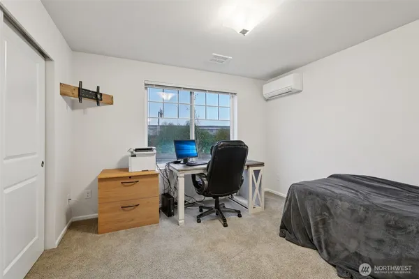 a view of a workspace with furniture and a window