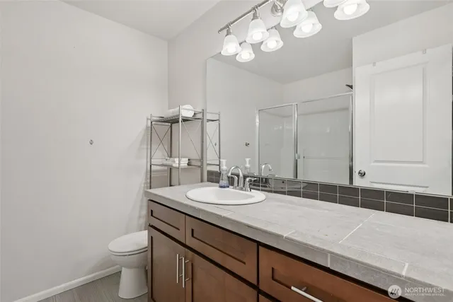 a bathroom with a granite countertop sink a toilet and a mirror