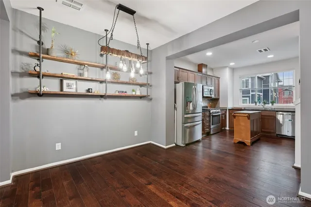 a kitchen with stainless steel appliances a refrigerator and wooden floor