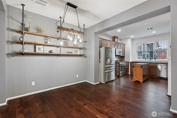 a kitchen with stainless steel appliances a refrigerator and wooden floor
