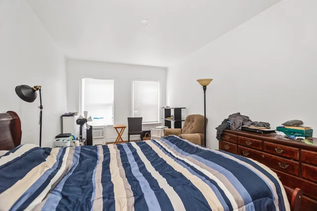 a bedroom with two beds and a chair