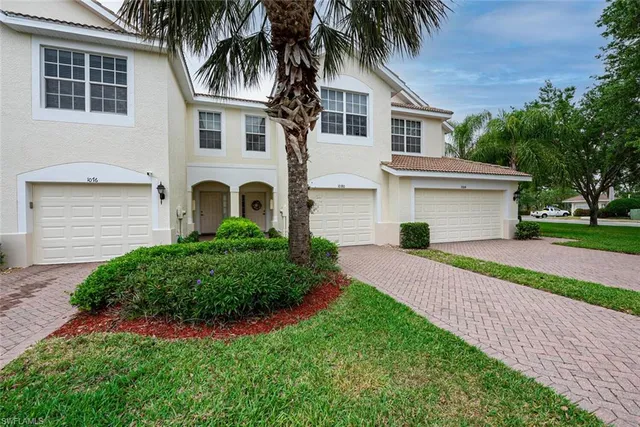 a front view of a house with a garden and trees