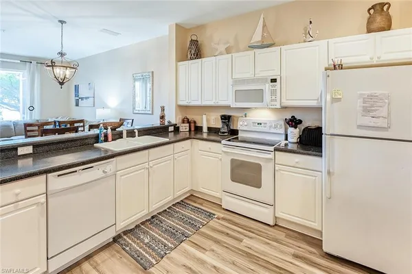 a kitchen with white cabinets and white appliances