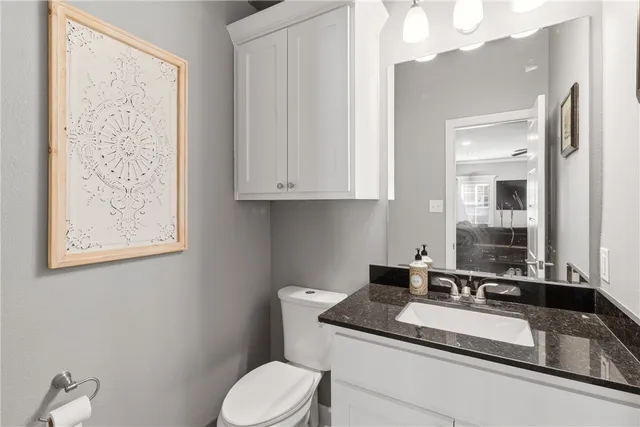 a bathroom with a granite countertop sink and a mirror with toilet