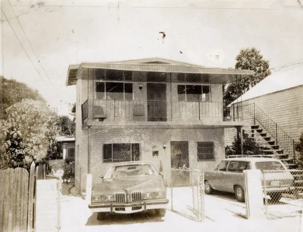 a front view of a building with cars parked