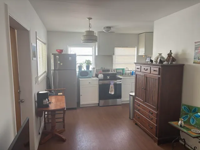 a kitchen with refrigerator and chairs