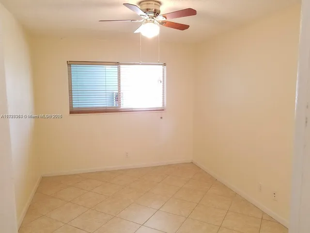 an empty room with a window and a fan