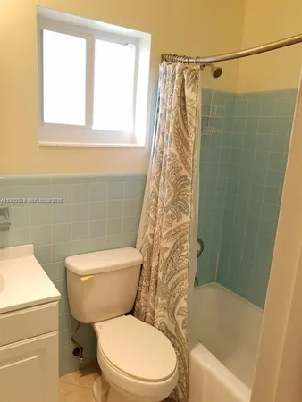 a white toilet sitting next to a bath tub shower