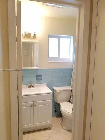 a bathroom with a toilet a sink and a mirror