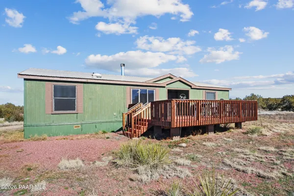 a view of a house with a yard and deck