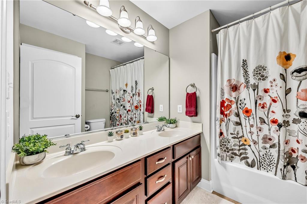 6410 Ashton Park Drive Oak Ridge, NC 27310 - Photo 26 of 49 Hall bathroom with double sinks. Tub/shower.