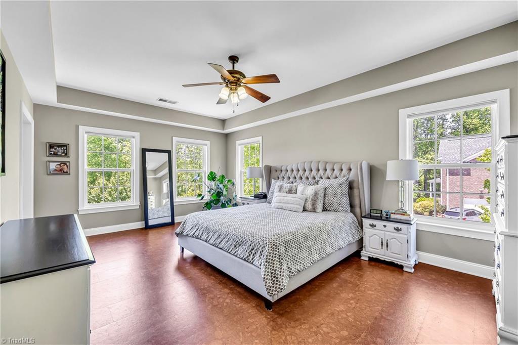 6410 Ashton Park Drive Oak Ridge, NC 27310 - Photo 29 of 49 Primary Bedroom with cork flooring and lots of natural light.