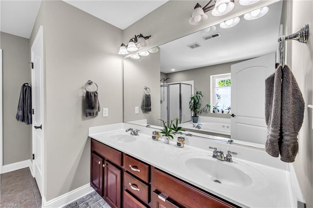6410 Ashton Park Drive Oak Ridge, NC 27310 - Photo 33 of 49 Primary bathroom, tile floor, double sinks.
