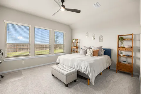 a spacious bedroom with a bed and a window