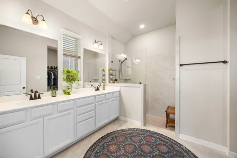 a spacious bathroom with a double vanity sink mirror and bathtub
