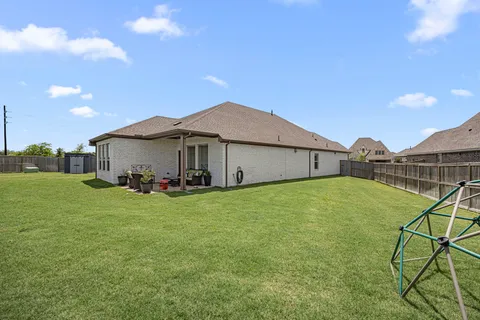 a view of a house with backyard and sitting area