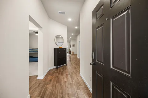 a view of a hallway with wooden floor and staircase
