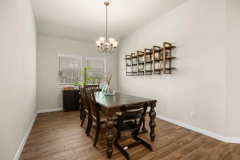 a view of a dining room with furniture a chandelier and wooden floor