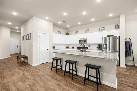 a kitchen with stainless steel appliances granite countertop a refrigerator and a stove top oven