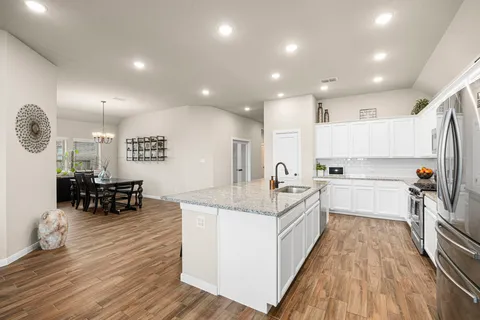 a kitchen with kitchen island granite countertop lots of counter top space and a sink