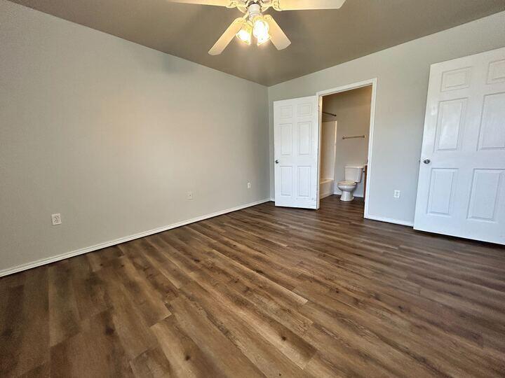 1116 82nd Street, Unit B Lubbock, TX 79423 - Photo 11 of 13 an empty room with wooden floor and windows