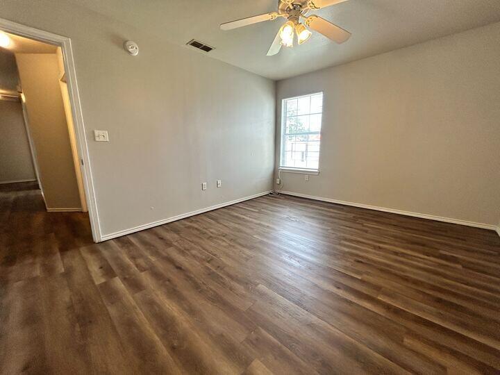 1116 82nd Street, Unit B Lubbock, TX 79423 - Photo 10 of 13 an empty room with wooden floor and windows