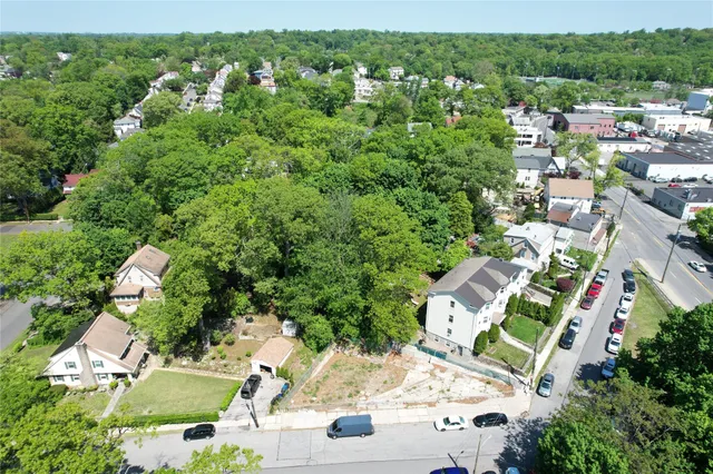 an aerial view of residential house with outdoor space and trees all around