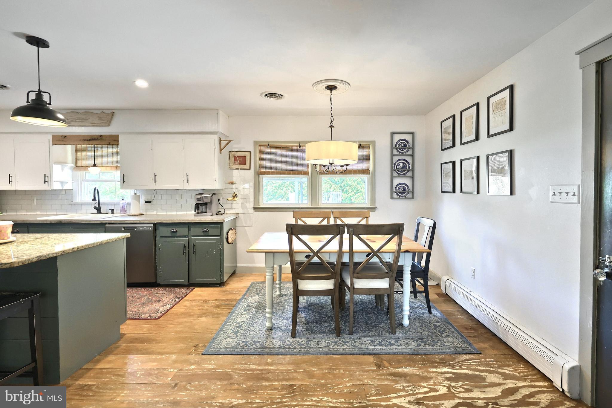 492 Bollinger Road Littlestown, PA 17340 - Photo 12 of 47 a kitchen with stainless steel appliances granite countertop wooden floor dining table and chairs