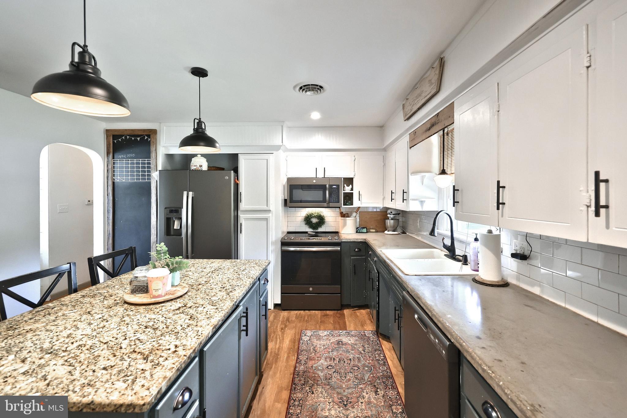 492 Bollinger Road Littlestown, PA 17340 - Photo 14 of 47 a kitchen with granite countertop kitchen island stainless steel appliances a sink stove and refrigerator