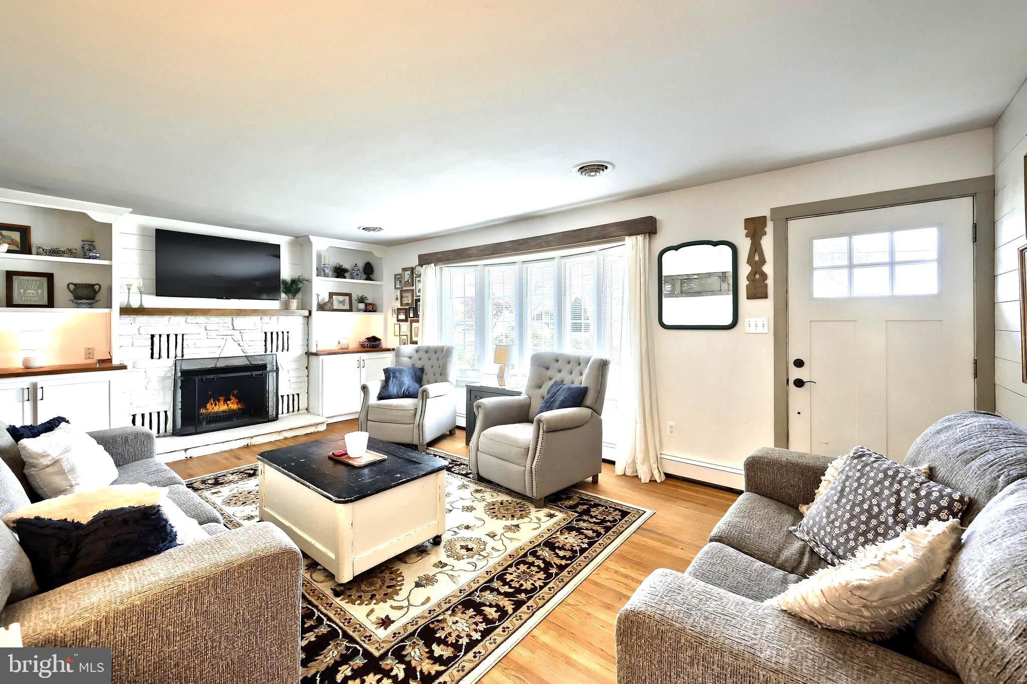 492 Bollinger Road Littlestown, PA 17340 - Photo 8 of 47 a living room with furniture a flat screen tv and a fireplace