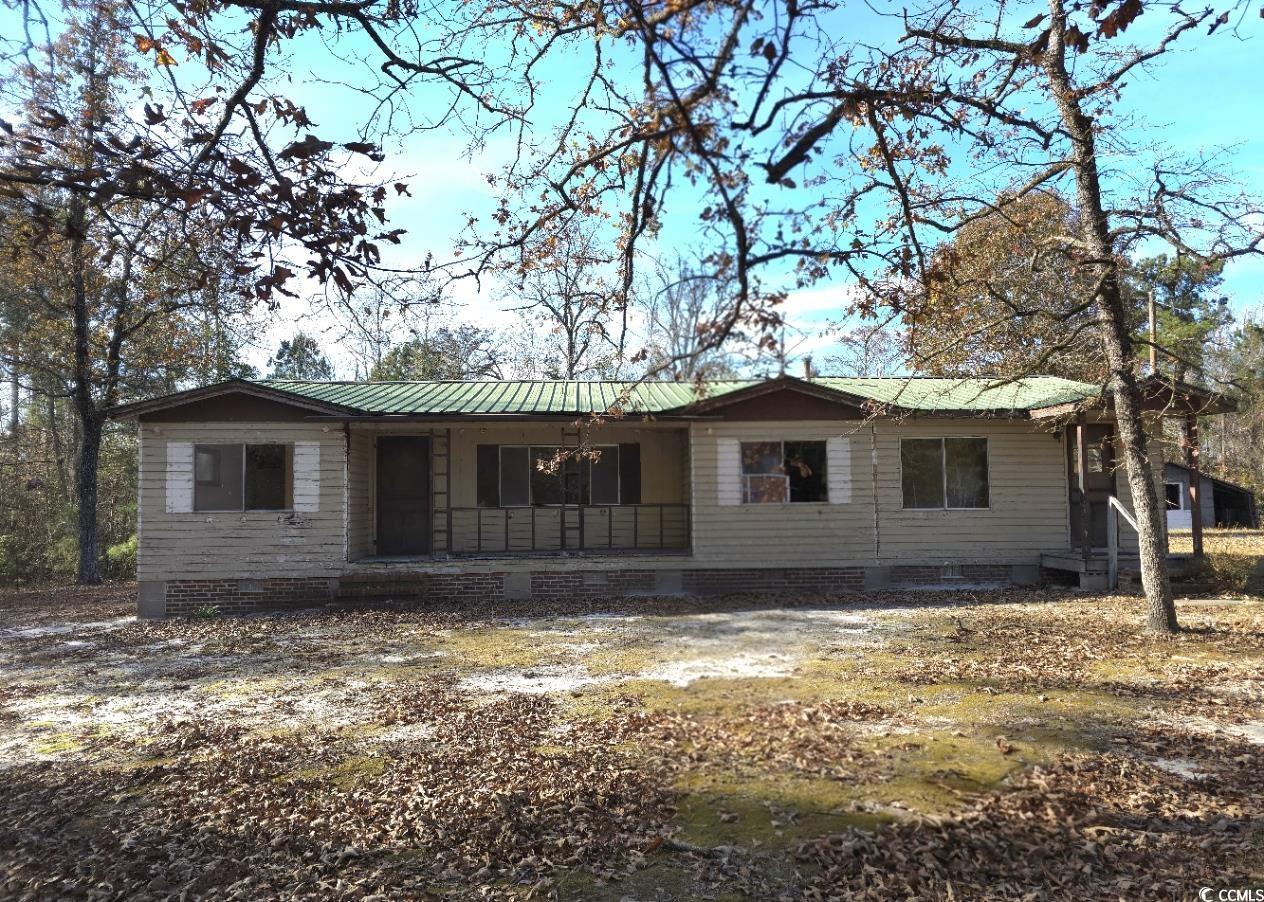 View of front facade featuring a porch, a metal roof, and crawl space