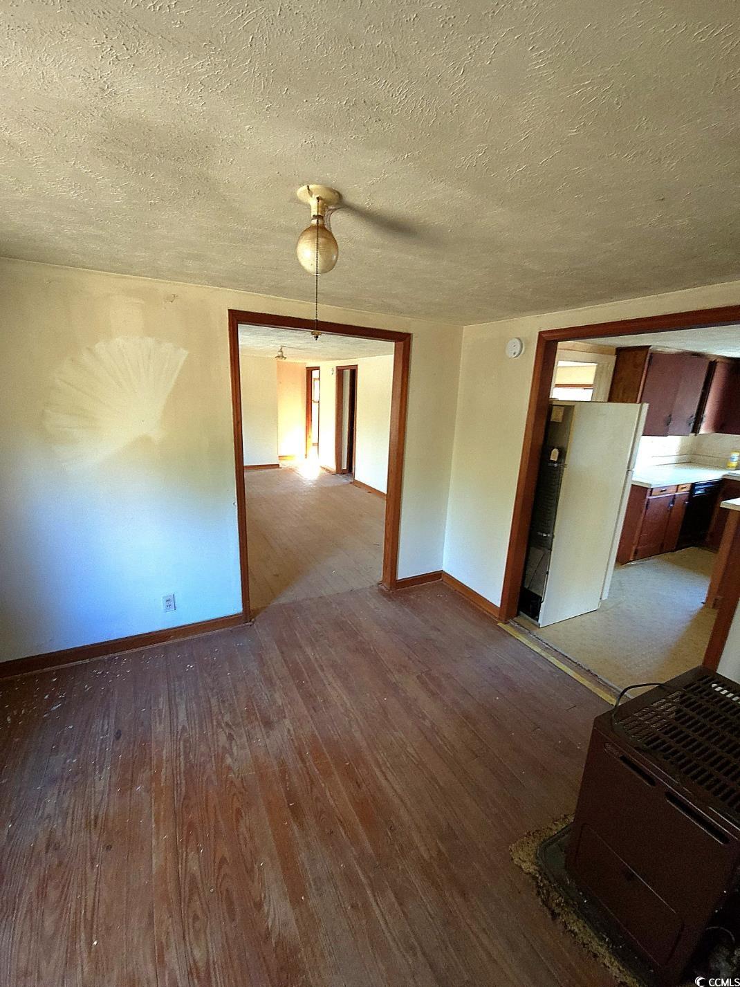 150 Landmark Road Conway, SC 29527 - Photo 11 of 35 Unfurnished living room featuring dark wood finished floors and a textured ceiling